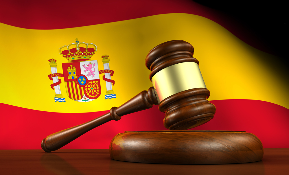 Młotek sędziowski na tle flagi Hiszpanii