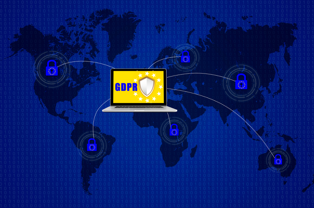 Kłódka na laptopie komutera nad mapą świata i symbolizująca ogólne rozporządzenie o ochronie danych UE lub RODO.